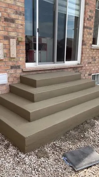 Finished concrete steps with a smooth brown finish leading to a sliding glass door